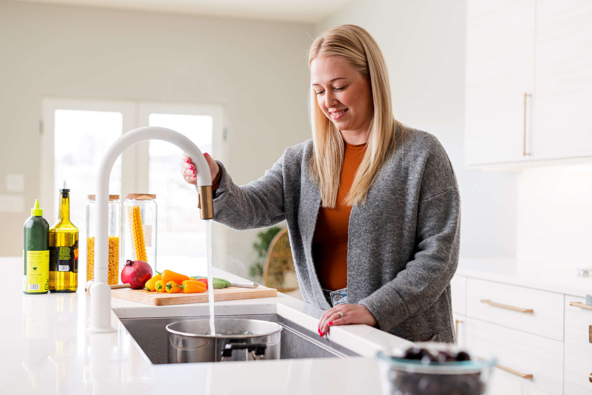 Woman using kitchen sink faucet